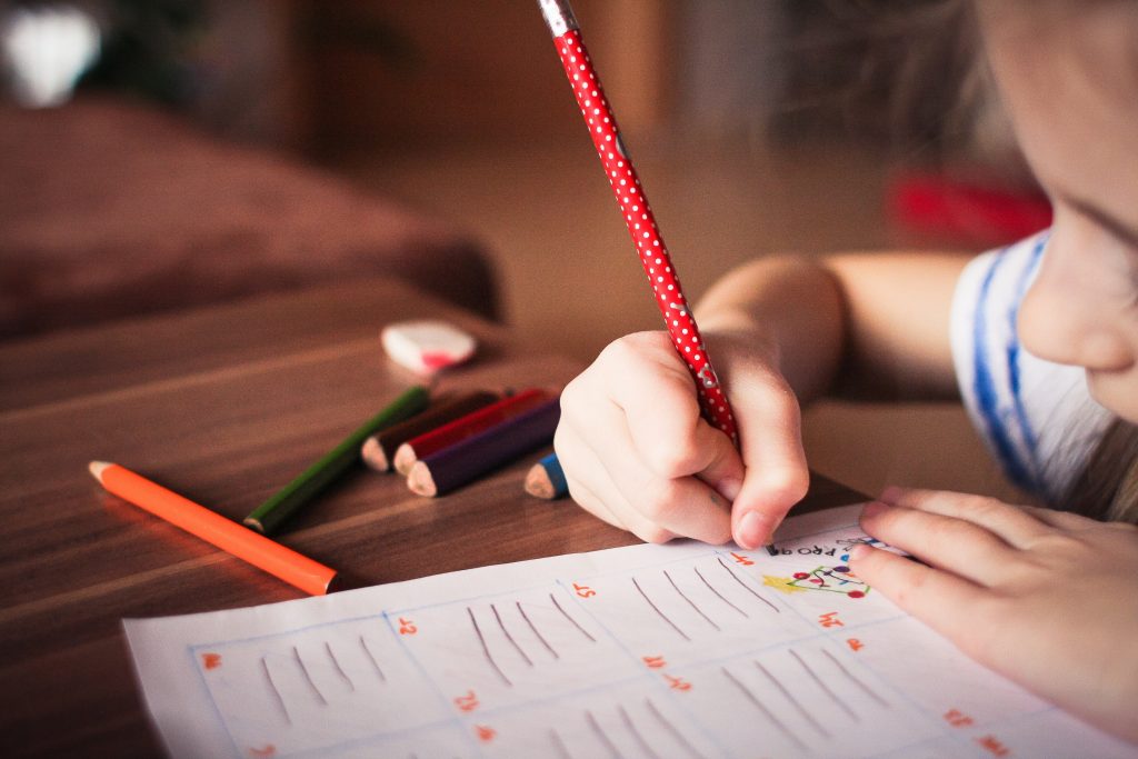 Child writing in a copy | St Columbanus National School